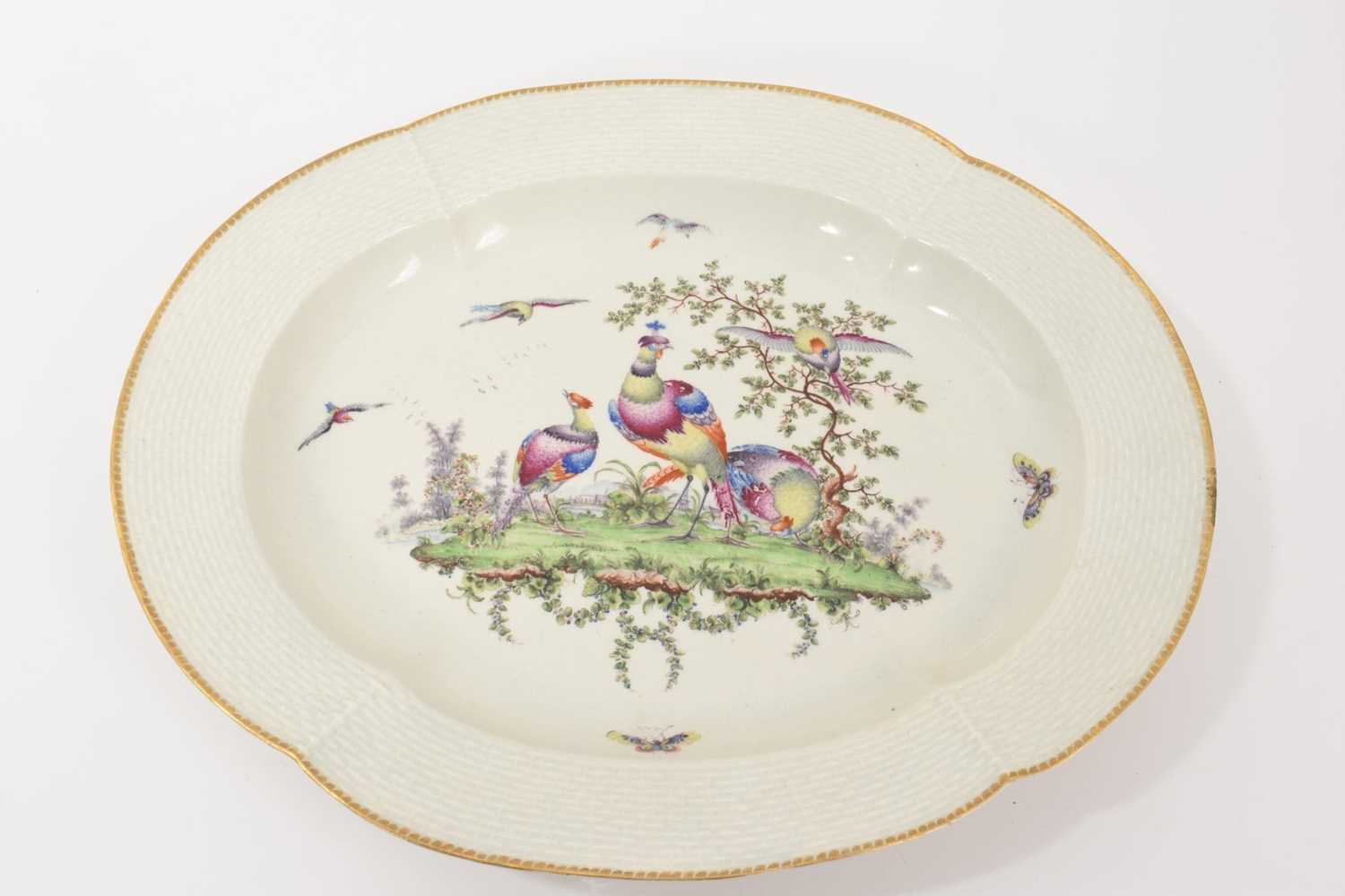 Lot 25 - A Worcester lobed dish with basketweave edge, circa 1772, polychrome painted with exotic birds, gilt dentil rim, 30cm diameter