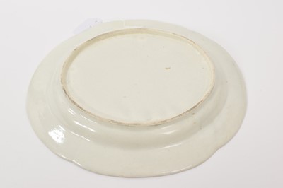 Lot 25 - A Worcester lobed dish with basketweave edge, circa 1772, polychrome painted with exotic birds, gilt dentil rim, 30cm diameter