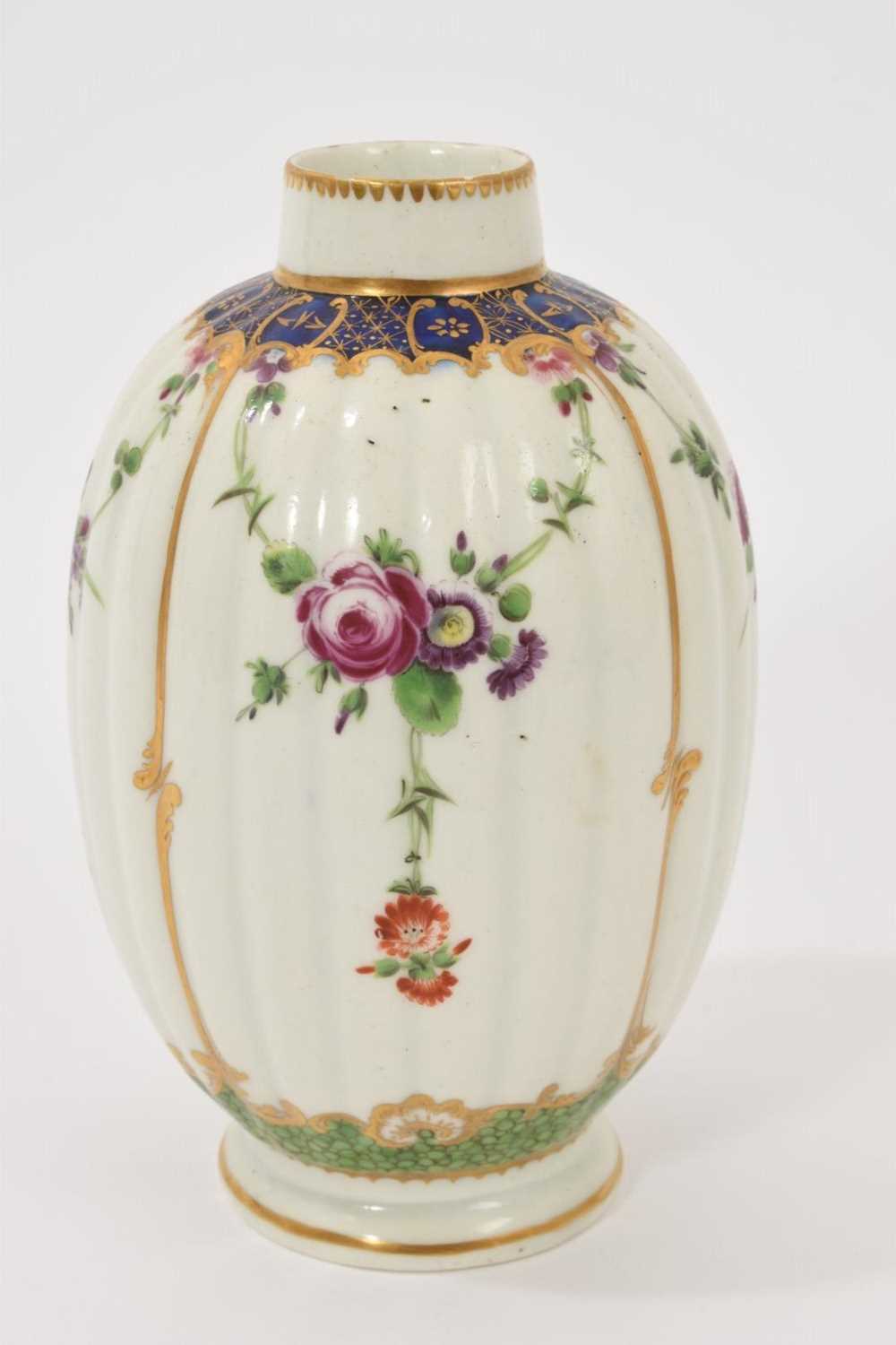 Lot 40 - A Worcester tea caddy, circa 1780, of fluted form, polychrome painted with floral swags in gilt panels, with a blue and gilt border, gilt dentil rim, the bottom with shagreen pattern, W mark to...