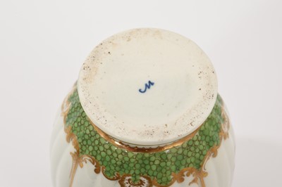 Lot 40 - A Worcester tea caddy, circa 1780, of fluted form, polychrome painted with floral swags in gilt panels, with a blue and gilt border, gilt dentil rim, the bottom with shagreen pattern, W mark to...