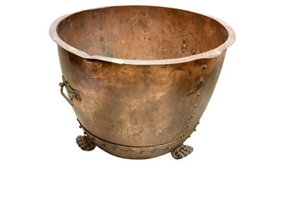 Lot 1443 - Large antique riveted copper cauldron with brass handles and paw feet, 53.5cm diameter