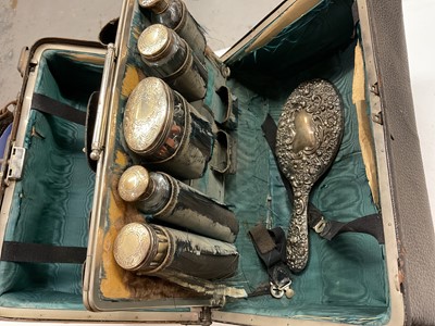 Lot 1146 - Vintage vanity case containing silver topped glass bottles, silver backed hand mirror, together with silver flatware etc