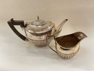 Lot 1069 - Silver bachelors teapot and matching milk jug, both with engraved crest