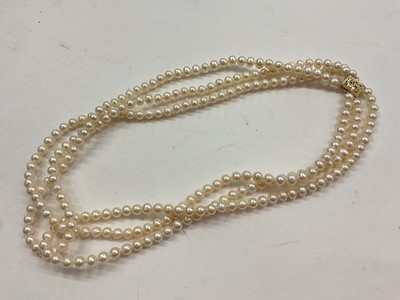 Lot 1072 - Cultured pearl three strand necklace with gold clasp, stamped 14K