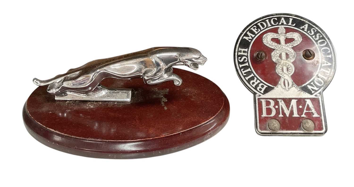 Lot 6 - Jaguar leaper car mascot, mounted on an oval wooden base, together with a British Medical Association car badge (2).