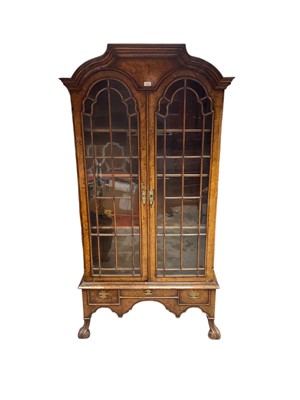 Lot 1385 - Early 20th century Queen Anne revival walnut veneered display cabinet with shelved interior enclosed by two glazed doors with two drawers below, 98cm wide, 36cm deep, 191.5cm high