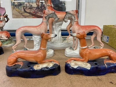 Lot 73 - Pair of Victorian Staffordshire greyhound inkwells, and a garniture of standing greyhounds with rabbits in their mouths (5)