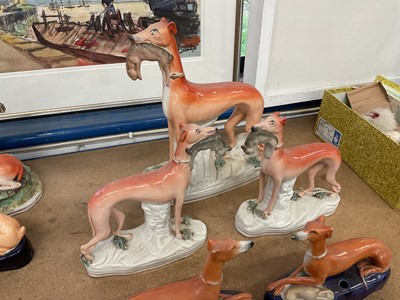 Lot 73 - Pair of Victorian Staffordshire greyhound inkwells, and a garniture of standing greyhounds with rabbits in their mouths (5)