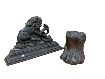 Lot 542 - Victorian door stop in the form of a lion fighting a snake and another lions paw door stop (2).