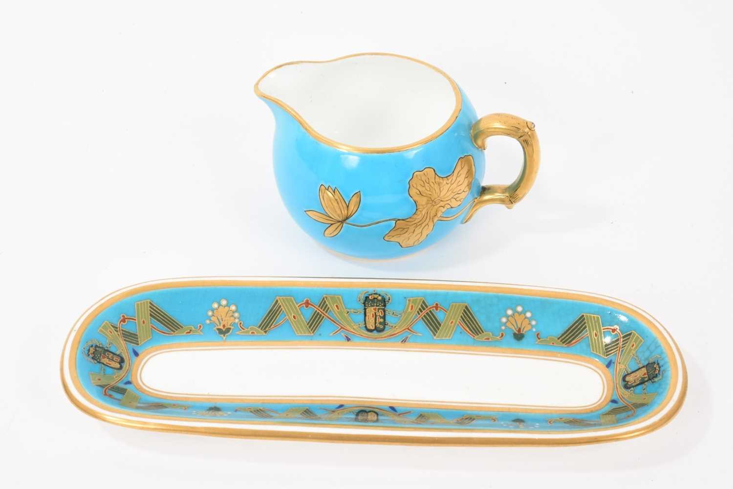 Lot 29 - Mintons Aesthetic style turquoise-ground pen tray decorated with insects and a stylised ribbon pattern, and a milk jug with lotus flowers in gilt relief