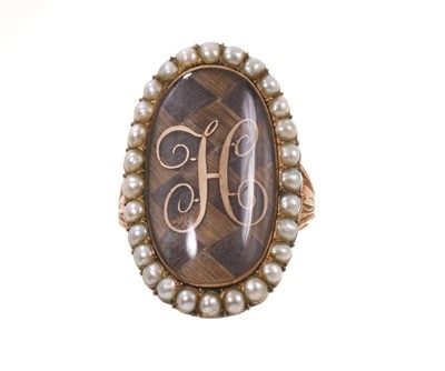 Lot George III gold and seed pearl mourning ring with a large oval glazed bezel containing a finely woven hair chequered panel surmounted by a gold initial 'H', surrounded by a seed pearl border, en...