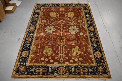 Lot 1742 - Good Indian Agra carpet, with broad lotus flower design on brick red ground, in main foliate meander border, 343 x 254cm