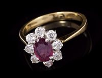 Lot 625 - Ruby and diamond cluster ring with an oval...