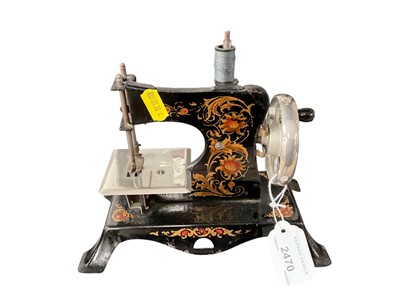 Lot 2470 - Miniature German tinplate sewing machine with gilt patterned decoration