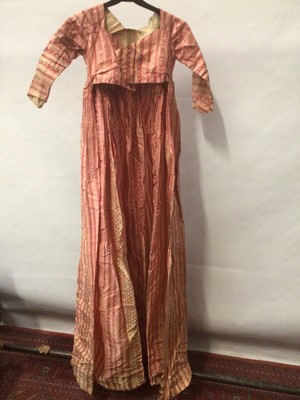 Lot 2054 - Late 18th century / 19th century Regency pink striped silk open skirt dress with high waist and cross front and pleated back. Seam opening at hip height both sides