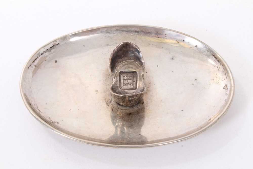 Lot 192 - Chinese silver dish of dished oval form on an oval base and mounted with a Chinese boat shaped silver Sycee ingot, underside with label referring to late 1920s. All at approximately 3ozs. 11cm a...