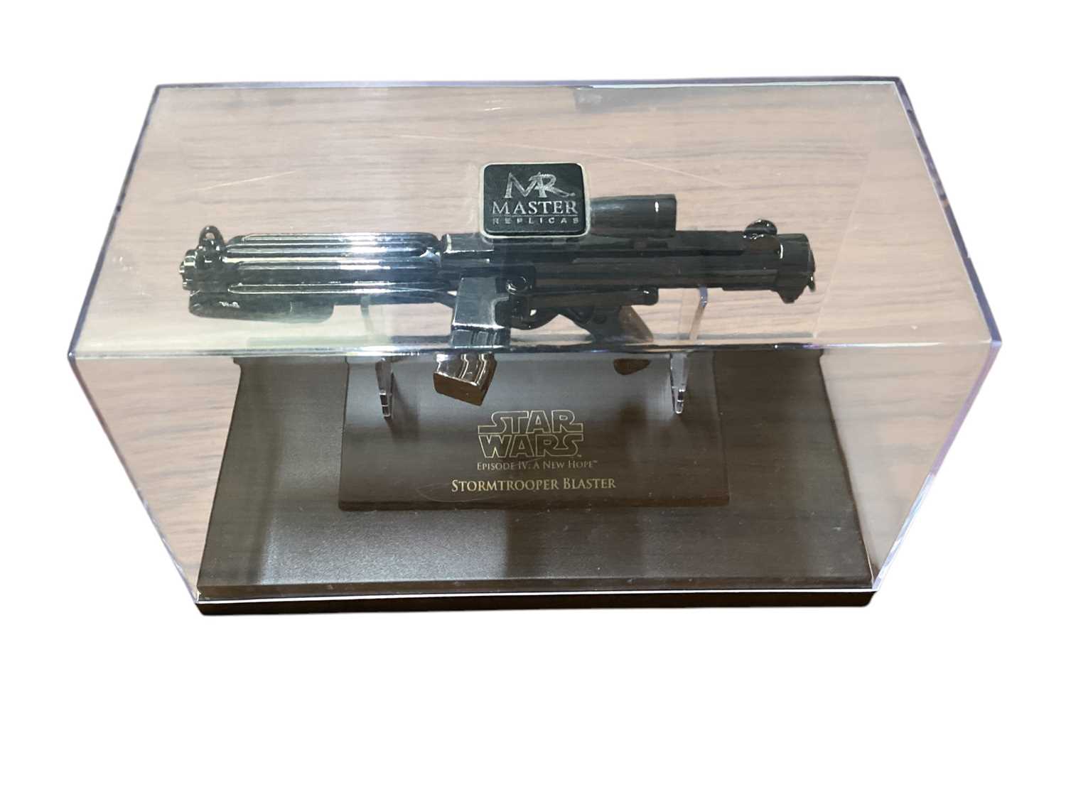 Lot 15 - Star Wars Master Replica Episode IV: A New Hope small scaled Stormtrooper Blaster & Episode V:The Empire Strikes Back Han Solo Blaster, both in display cases