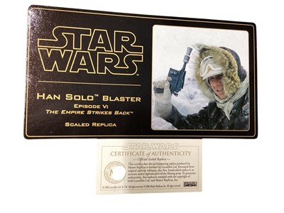 Lot 15 - Star Wars Master Replica Episode IV: A New Hope small scaled Stormtrooper Blaster & Episode V:The Empire Strikes Back Han Solo Blaster, both in display cases