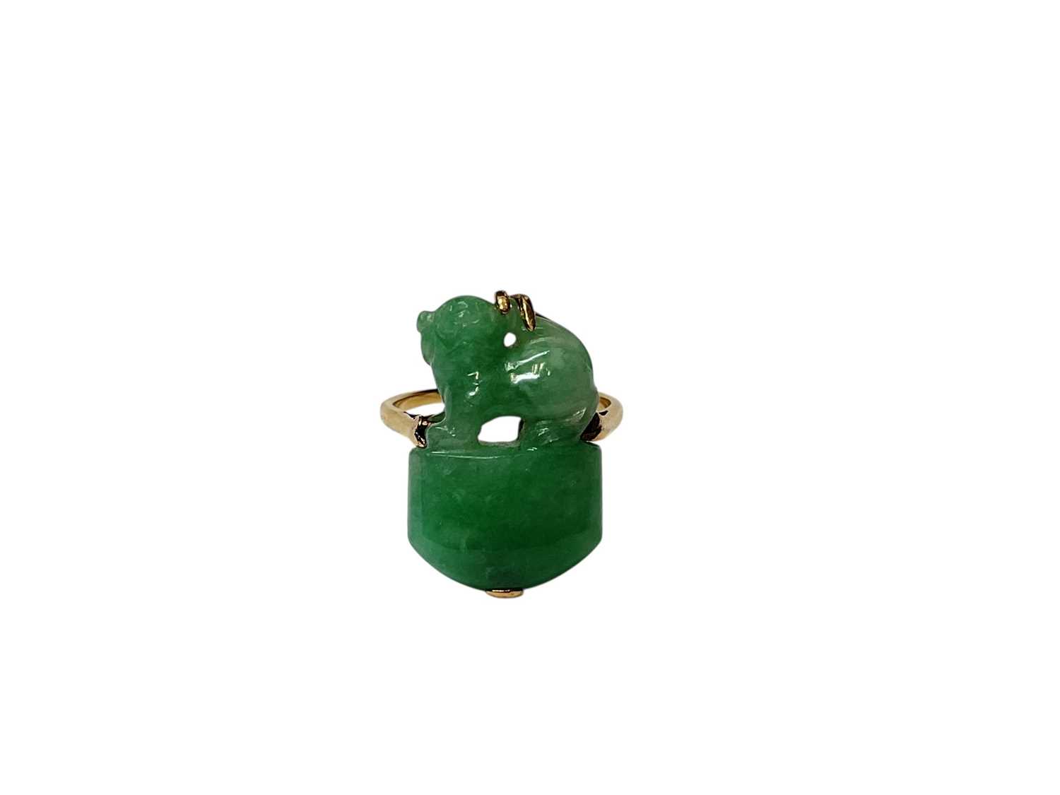 Lot 13 - Carved jade/ green hardstone ring depicting a dog of foo, in a yellow metal mount. Ring size K½