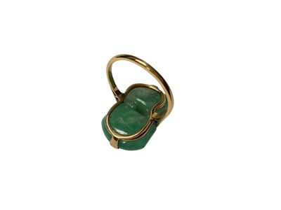 Lot 13 - Carved jade/ green hardstone ring depicting a dog of foo, in a yellow metal mount. Ring size K½