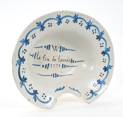Lot 34 - Rare 18th century French faience barber's bowl, inscribed 'W - la fin de lannée 1779', with blue swag and dot border, 30.5cm wide