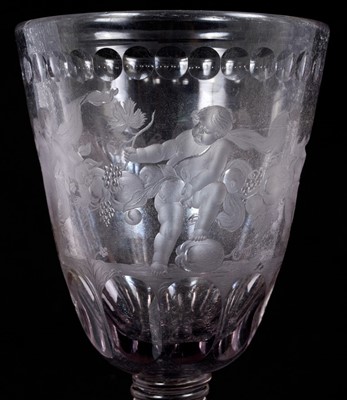 Lot 26 - Large Bohemian cut and engraved glass goblet and domed cover, circa 1730, well engraved with five putti around the body struggling with a heavy swag of pomegranates, grapes and other fruit, be...