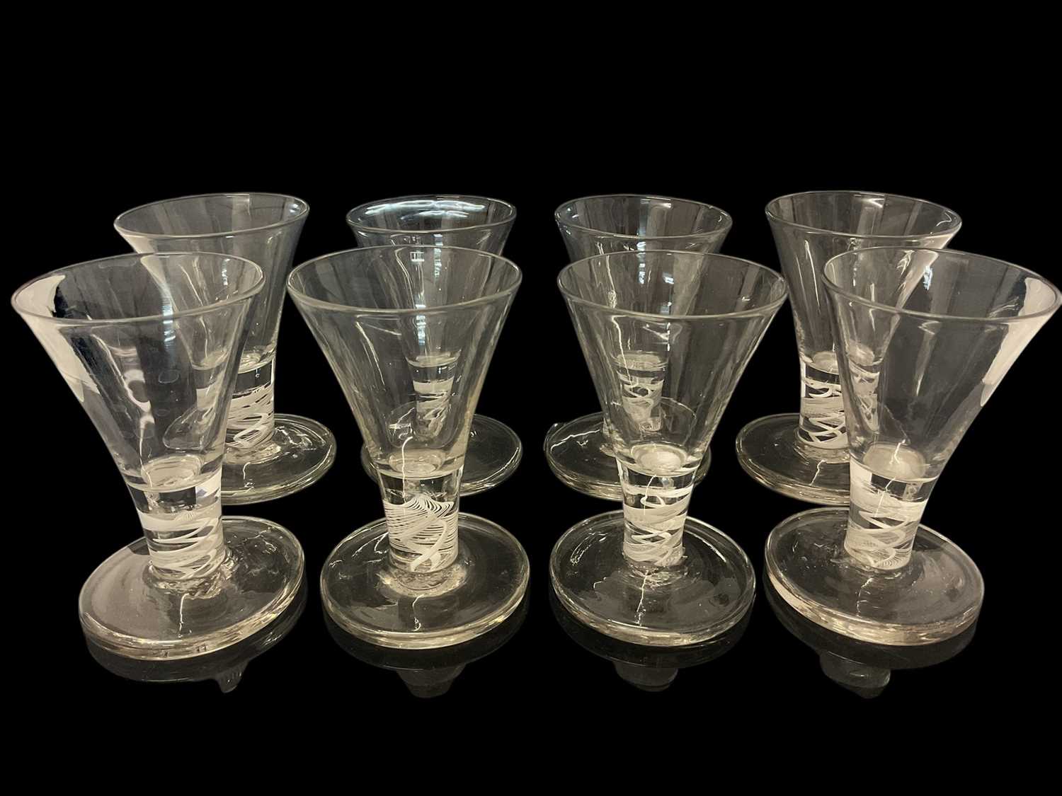 Lot 25 - Set of eight short firing glasses, 20th century, with trumpet bowls and double series opaque twist stems, 10cm high (8)