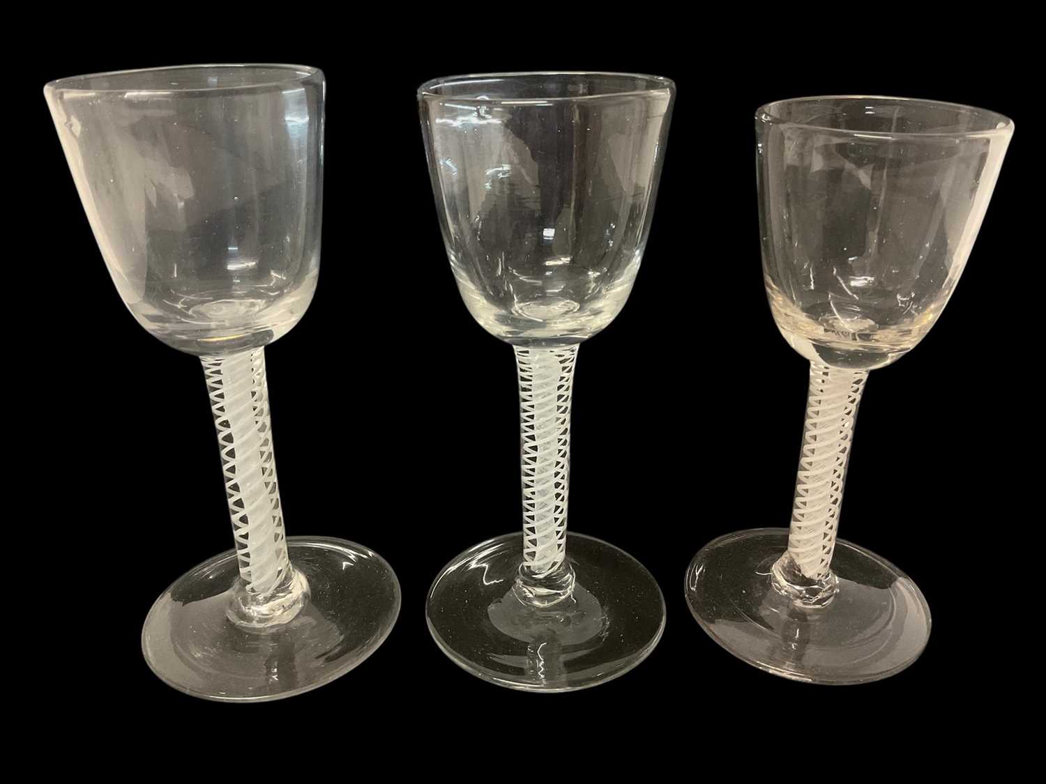 Lot 21 - Three 18th century double series opaque twist wine glasses, with round funnel bowls, plain stems and feet, 14.5cm to 15.25cm high
