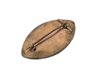 Lot 450 - George III mourning brooch of navette form, the ivory plaque painted in sepia depicting a lady standing by a gold and seed pearl urn on pedestal