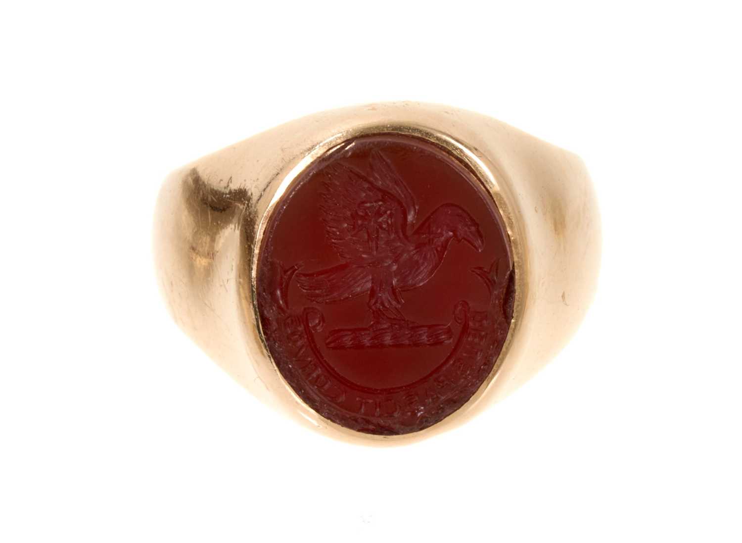 Lot 457 - Gold signet ring with an oval intaglio carved carnelian depicting a family crest and motto (London 1977). Ring size N-N½