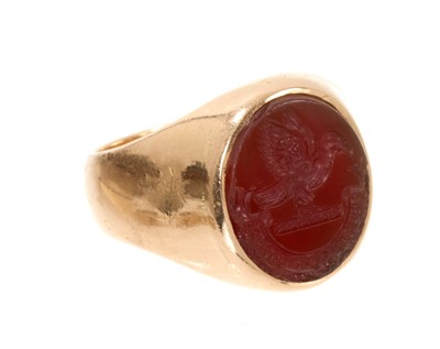 Lot 457 - Gold signet ring with an oval intaglio carved carnelian depicting a family crest and motto (London 1977). Ring size N-N½