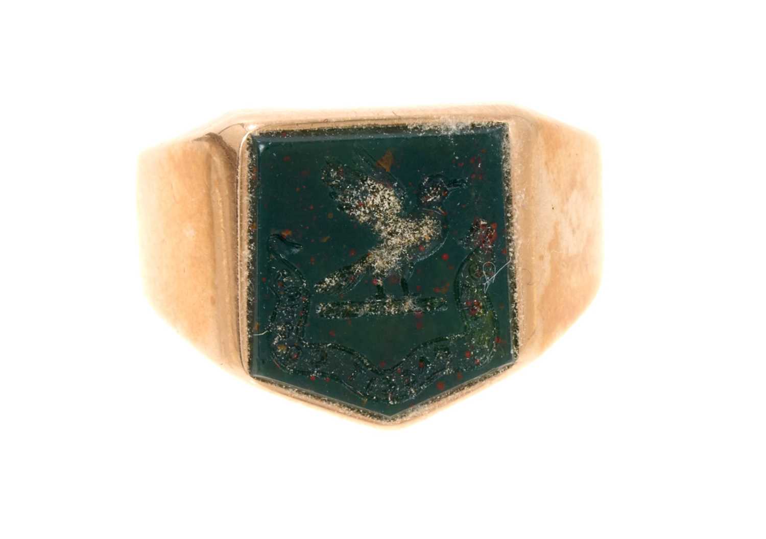 Lot 458 - Gold signet ring with a shield shape intaglio carved bloodstone depicting a family crest and motto in 15ct gold mount. Ring size O½