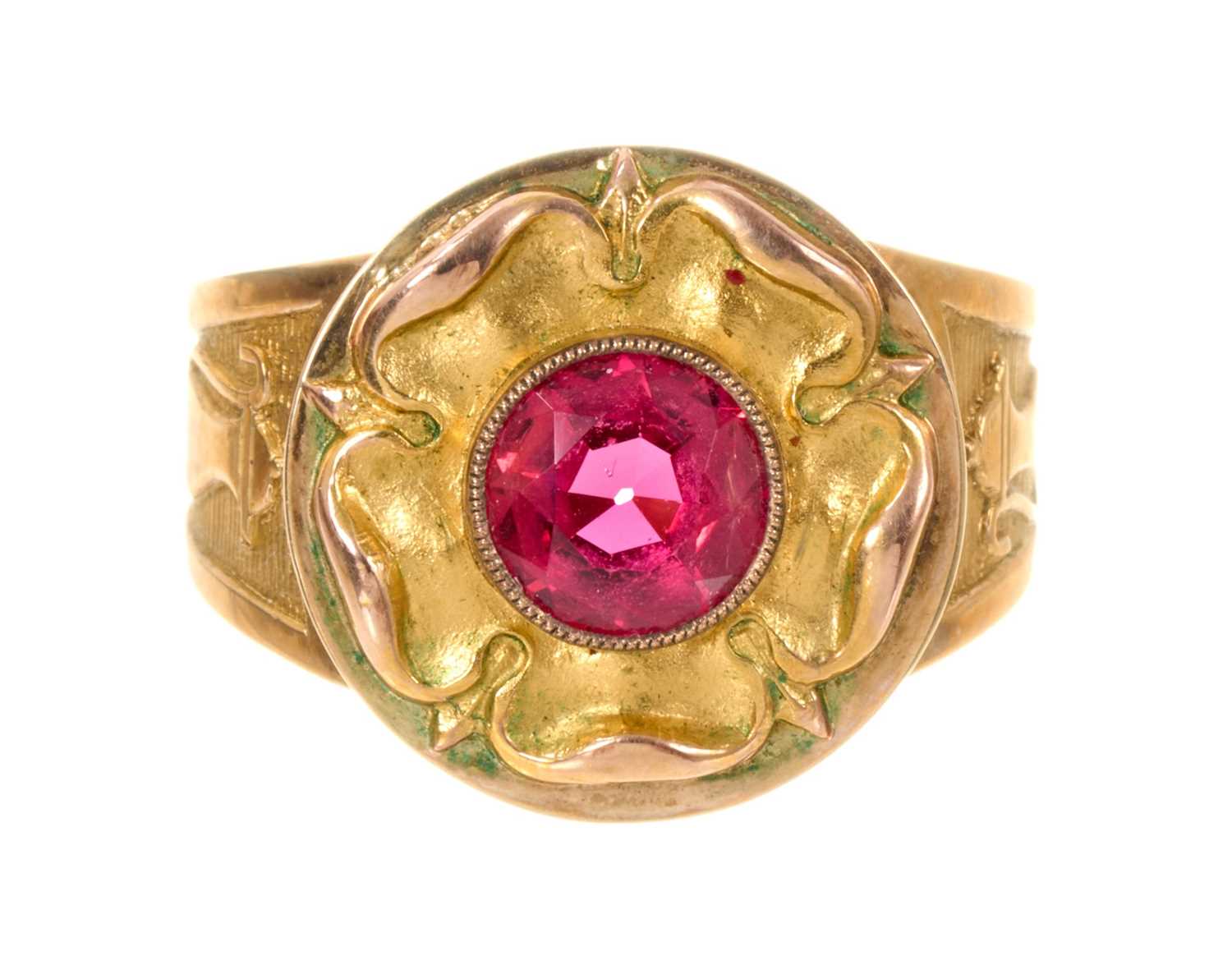 Lot 462 - Gold 'bishop' ring with stylised Tudor rose inset with a round mixed cut red stone, each tapered gold shoulder with an ecclesiastical ewer