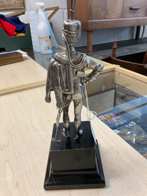 Lot 117 - Good quality 20th century silver model of a Hussar Officer in full dress, with sword, mounted on an ebonised wood plinth (London Assay marks only, no date letter or maker visible).