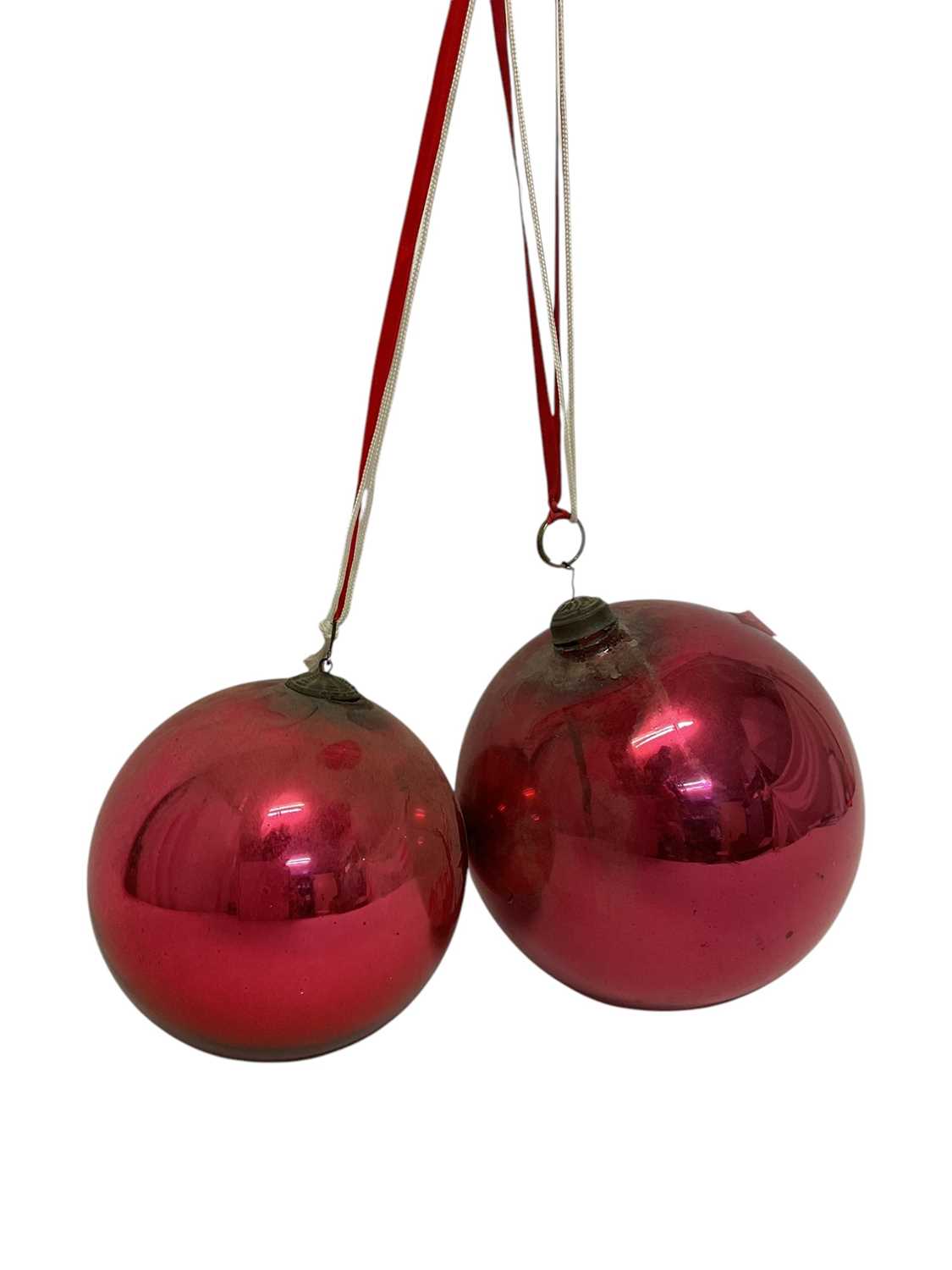 Lot 799 - Two red glass witch balls, each approximately 18cm and 14cm diameter respectively