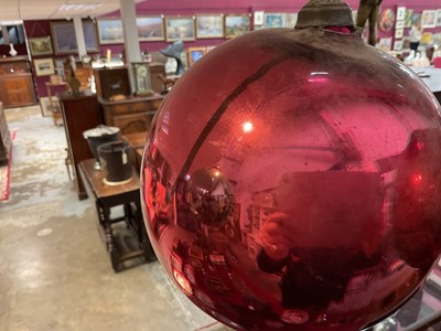 Lot 799 - Two red glass witch balls, each approximately 18cm and 14cm diameter respectively