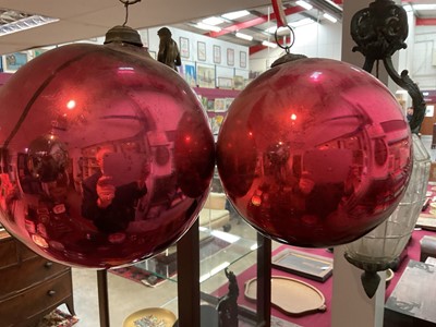 Lot 799 - Two red glass witch balls, each approximately 18cm and 14cm diameter respectively