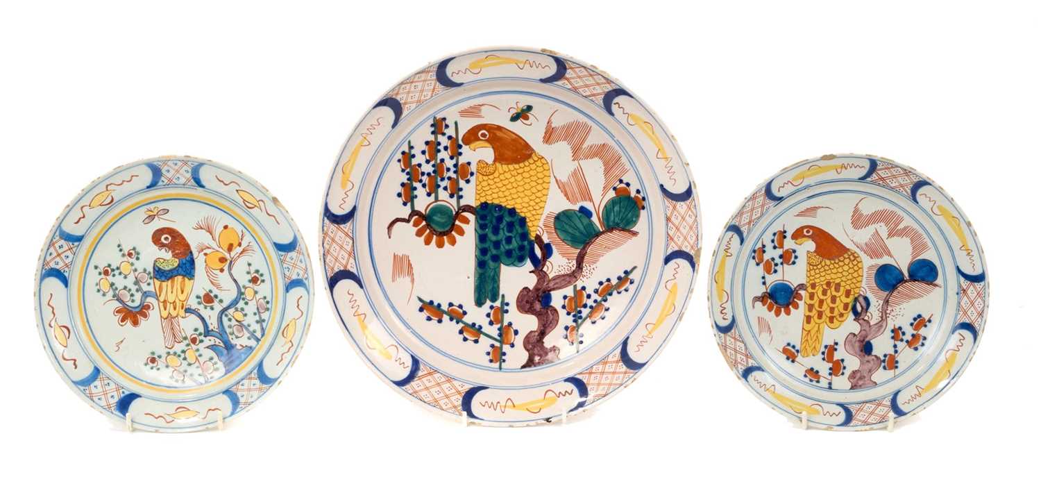 Lot 5 - Trio of 18th century Dutch delftware plates, polychrome painted in the Chinese style with parrots, the smaller two measuring 22cm and 22.5cm diameter, the larger measuring 30.5cm