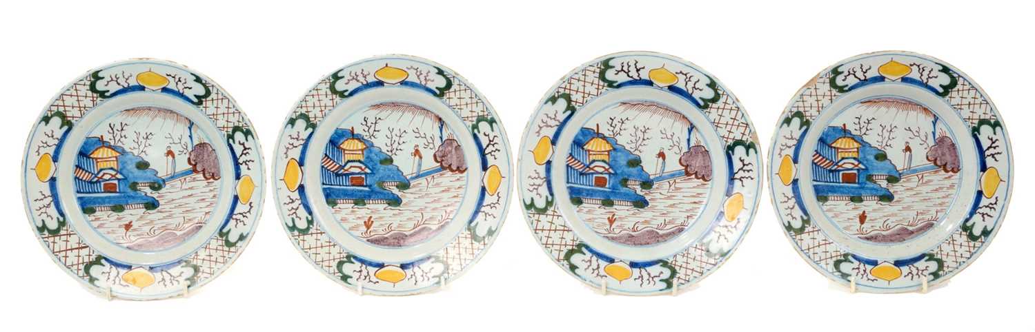Lot 3 - Set of four 18th century Delft plates, polychrome painted in the Chinese style with a figure on a bridge near a pagoda, 23cm diameter