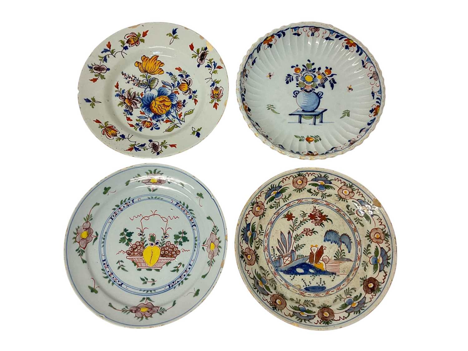 Lot 131 - Four 18th century Delft plates, including one with a Chinese figure in a garden, 22cm to 23cm diameter (4)