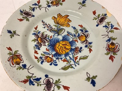 Lot 131 - Four 18th century Delft plates, including one with a Chinese figure in a garden, 22cm to 23cm diameter (4)