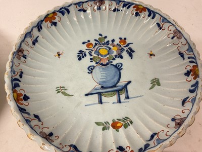 Lot 131 - Four 18th century Delft plates, including one with a Chinese figure in a garden, 22cm to 23cm diameter (4)