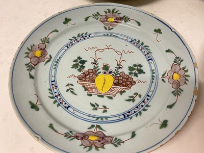 Lot 131 - Four 18th century Delft plates, including one with a Chinese figure in a garden, 22cm to 23cm diameter (4)