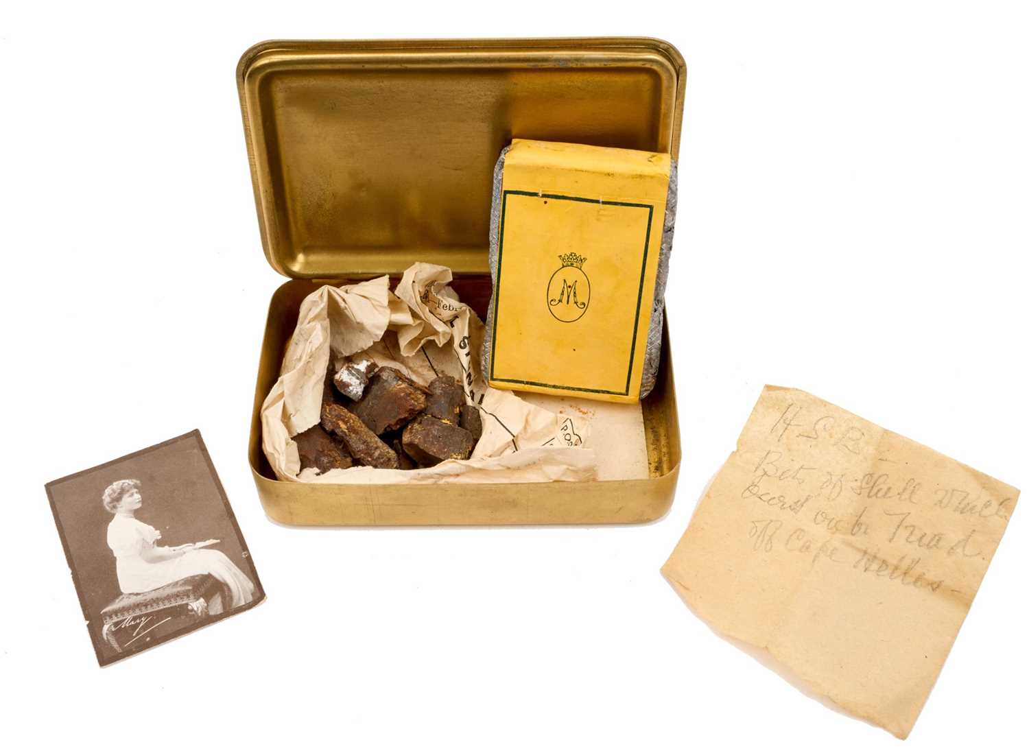 Lot 49 - First World War Princess Mary Gift Tin with original tobacco packet, Christmas card and photograph of Princess Mary. Together with pieces of shrapnel with annotation "HSB, bits of shell which bu...