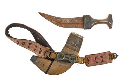 Lot 147 - Early 20th century Arab Jambia dagger with silver mounts and horn grip, curved blade with central rib, in original sheath with woven belt.