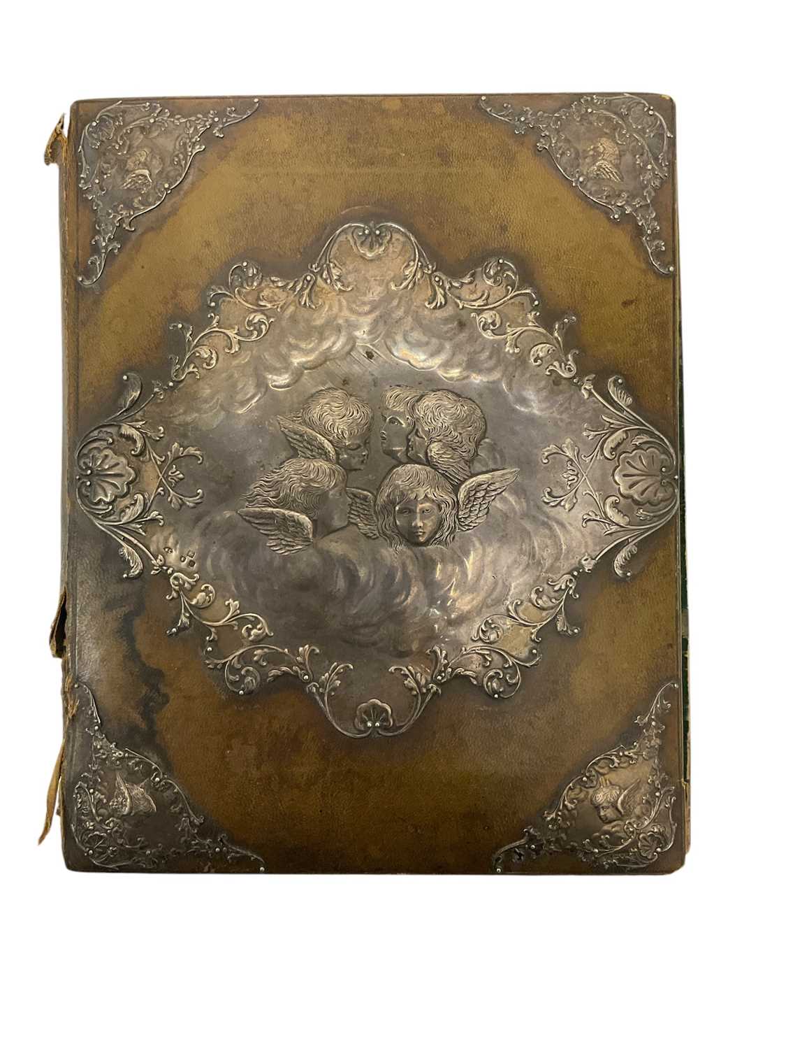 Lot 419 - Victorian silver desk blotter by William Comyns, decorated in relief with winged cherubs
