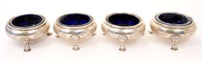 Lot 509 - Set of four cauldron silver salts with blue glass liners and engraved crests, on three pad feet