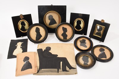 Lot 906 - Manner of Augustin Edouart (1788-1861) silhouette on paper of a gentleman seated in a library chair, 19 x 19cm and a collection of 19th century silhouettes and papercuts