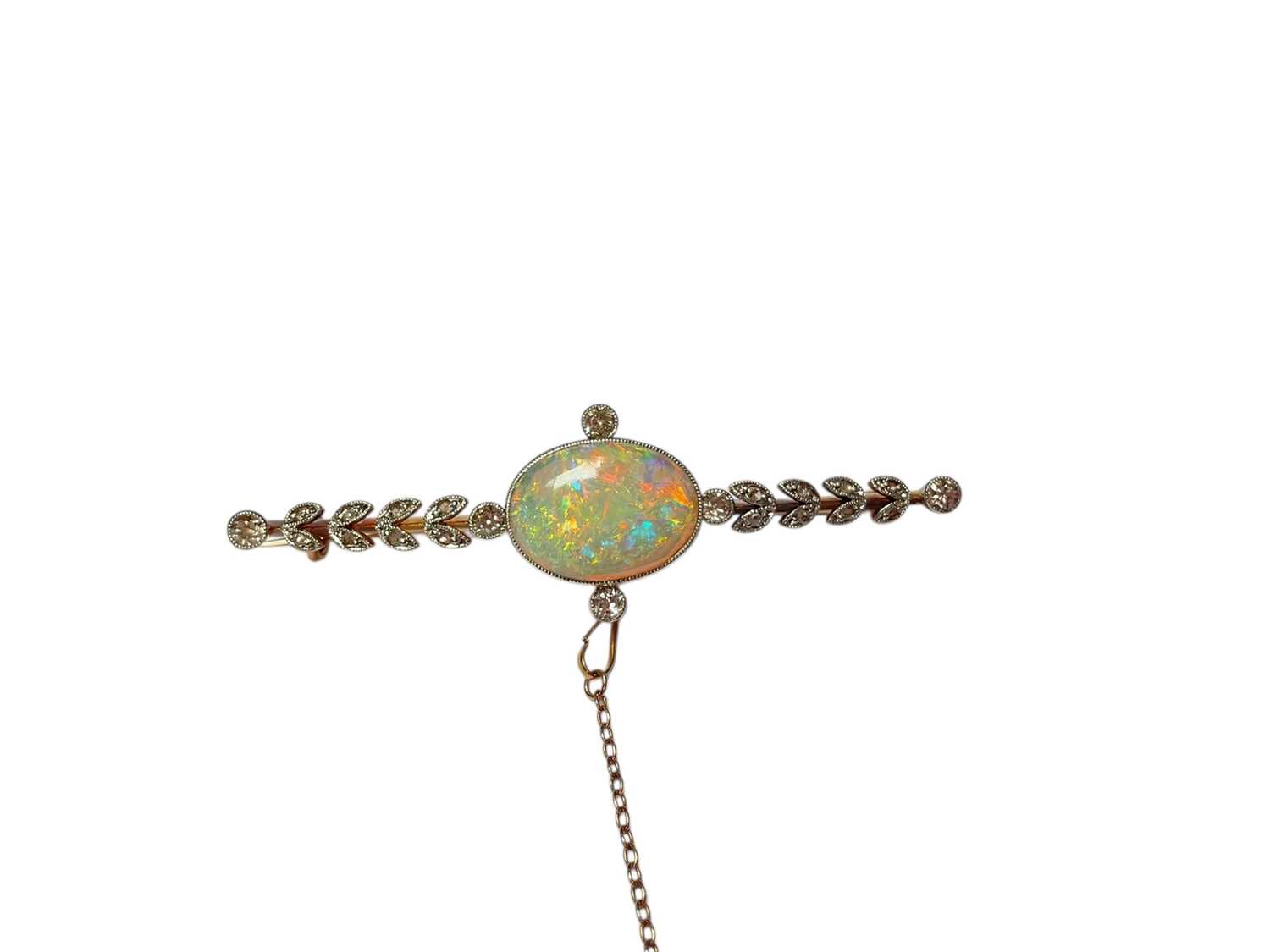 Lot 90 - Opal and diamond gold bar brooch with a central oval polished opal in a millegrain setting flanked by four old cut diamonds and further diamond set leaves to the bar