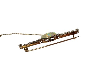 Lot 90 - Opal and diamond gold bar brooch with a central oval polished opal in a millegrain setting flanked by four old cut diamonds and further diamond set leaves to the bar